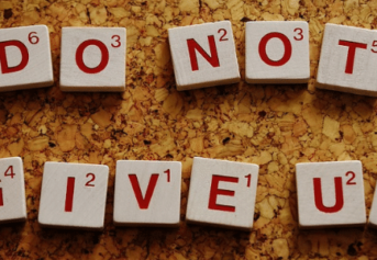 Scrabble pieces spelling out "Do not give up"
