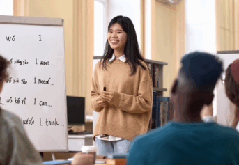 Students learn Chinese by writing characters on the board.